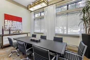 a conference room with a large table and chairs and windows